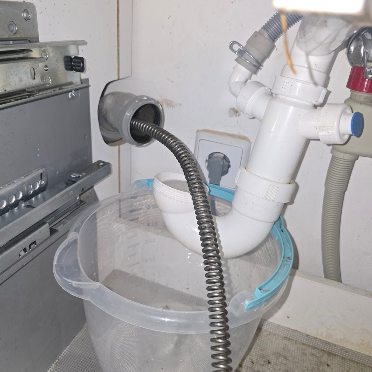 Rohrreinigungsspirale im Abflussrohr unter der Küchenspüle, Siphon demontiert – Küchenabfluss-Reinigung in Berlin Mitte