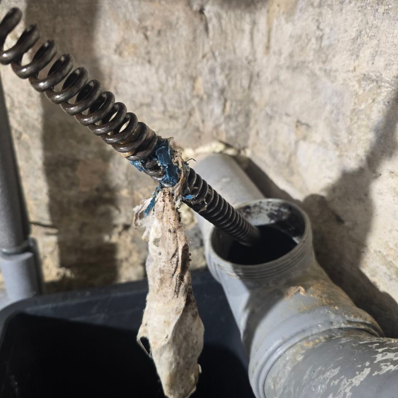 Rohrreinigungsspirale mit entferntem Pfropfen aus dem HT-Rohr im Keller – Kellerrohr-Reinigung in Berlin